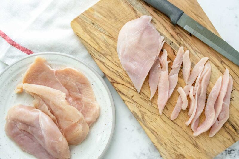 raw chicken breasts on a plate and cutting board