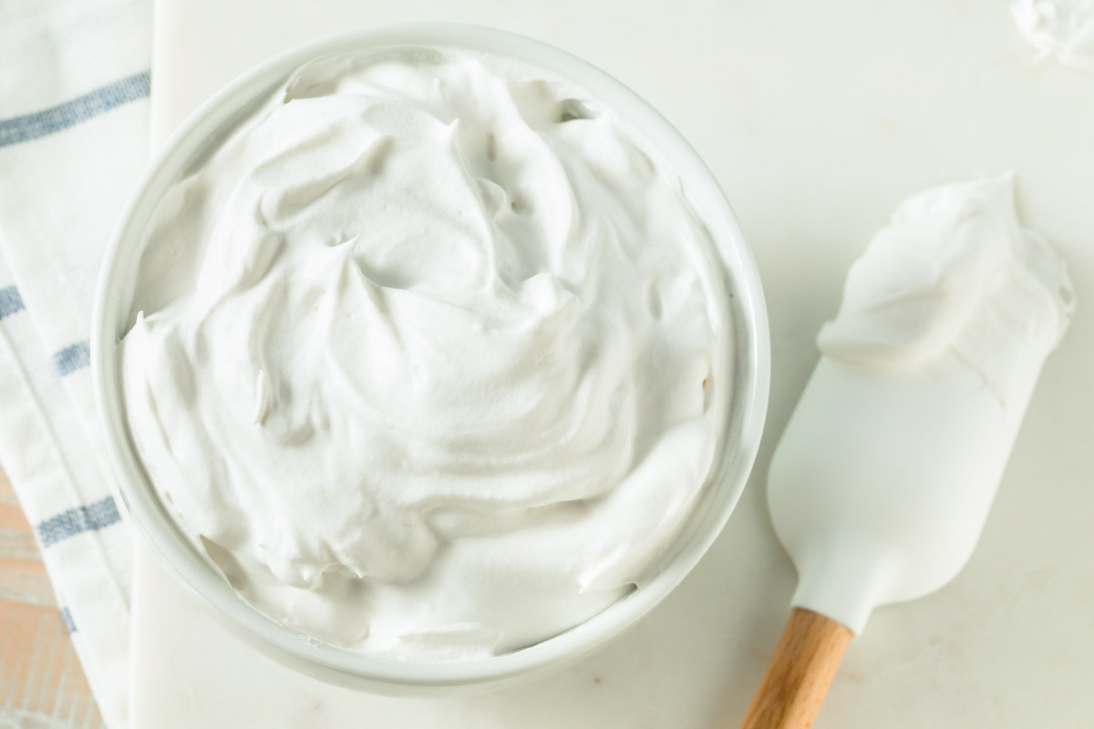 overhead view of whipped cream in a bowl and on a spatula