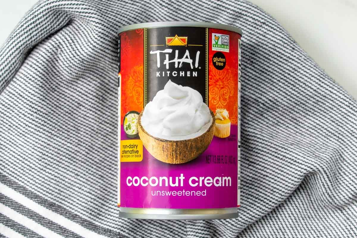 A can of unsweetened coconut cream resting on a kitchen towel.