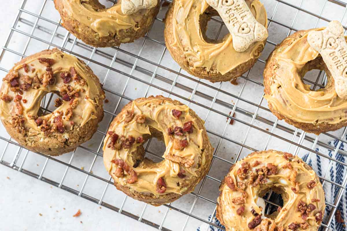 iced peanut butter dog donuts on a wire rack.