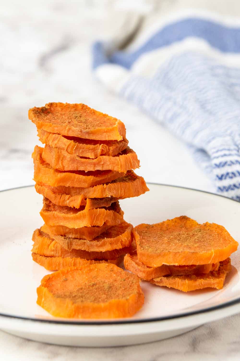Homemade dehydrated sweet potato dog chews on a plate.