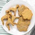dog and paw shaped dog treats without peanut butter on a plate.