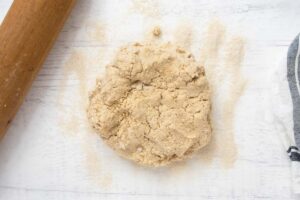 peanut butter oatmeal dog treats dough on a floured surface.