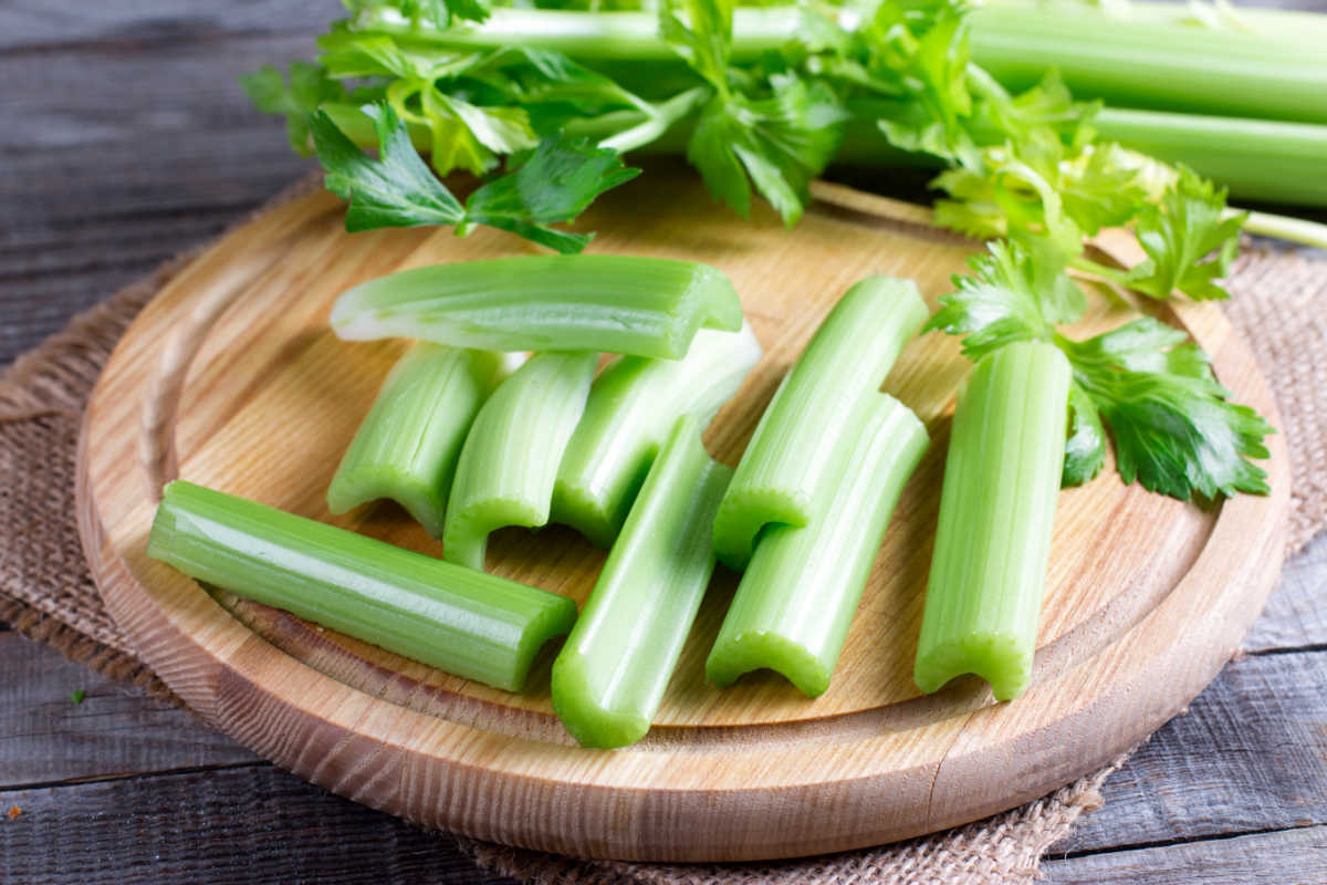 celery sticks on a round wood board.