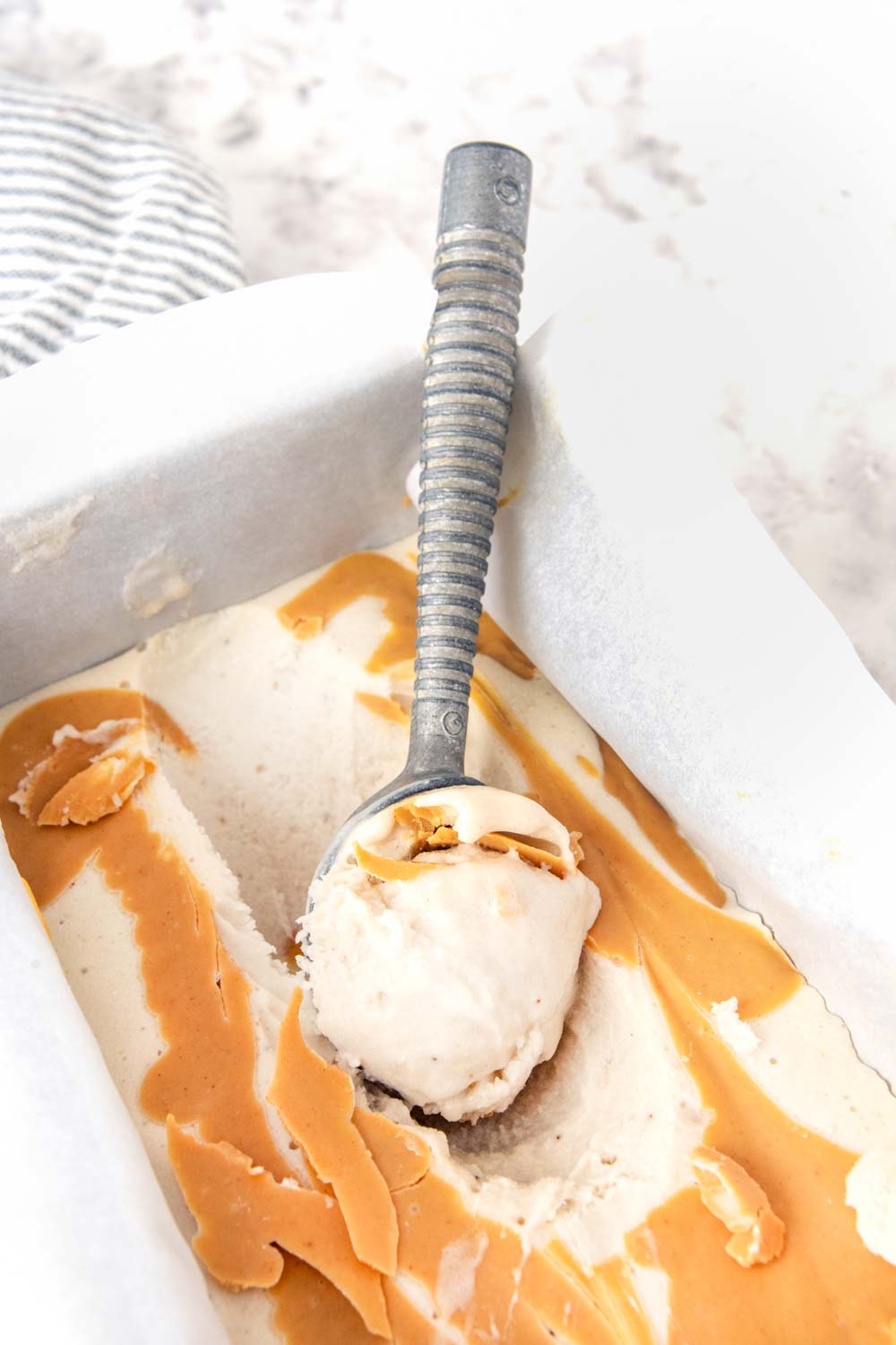 Banana peanut butter ice cream for dogs in a container.