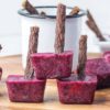 homemade mixed berry dog popsicles with dog chew popsicle sticks.