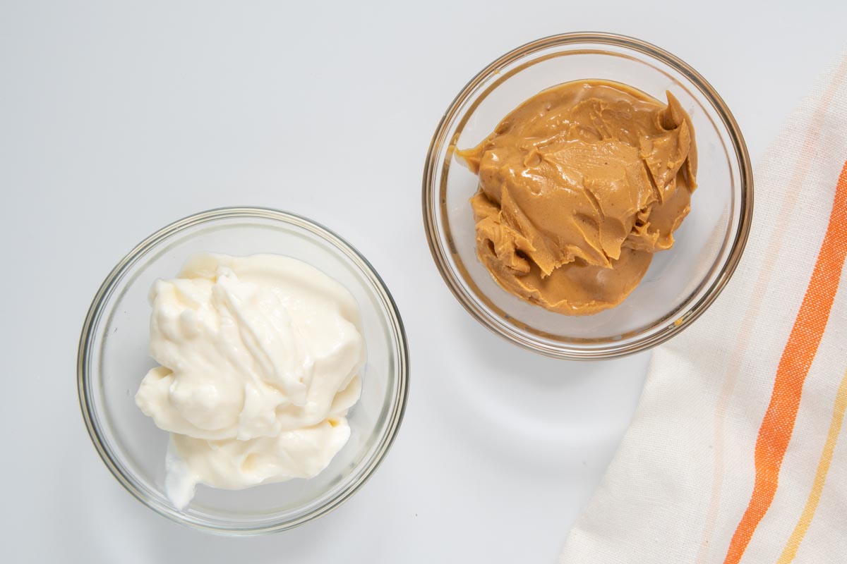 creamy peanut butter and plain Greek yogurt in bowls.