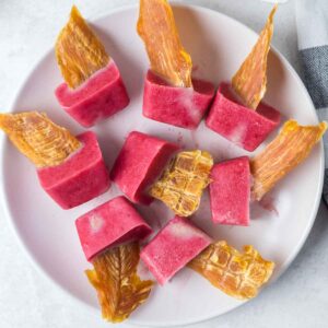 Strawberry popsicles for dogs on a plate.