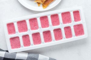 strawberry coconut milk mixture in an ice cube tray.