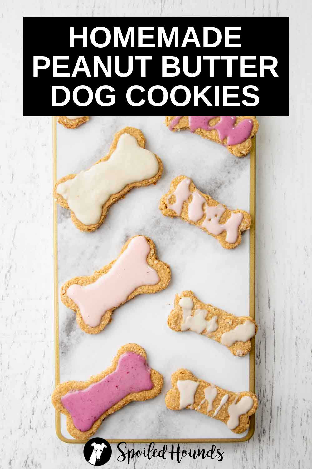 overhead view of iced peanut butter dog cookies on a marble board.