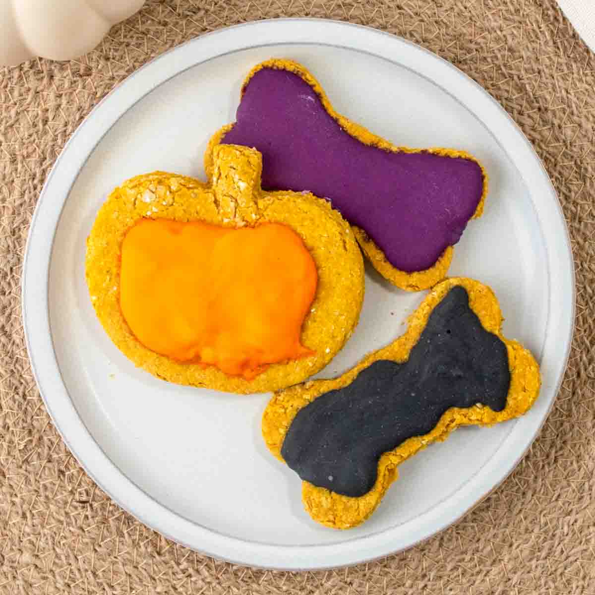 homemade Halloween dog treats with icing on a plate.