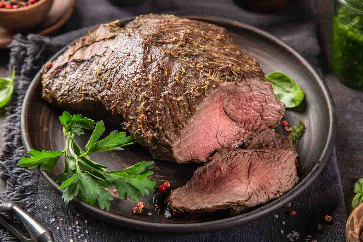 roast beef and parsley on a round plate.