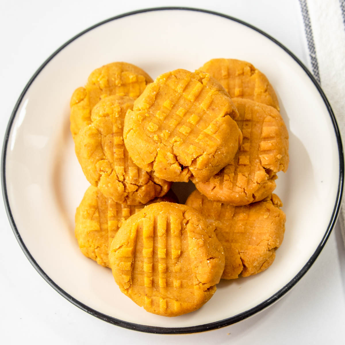 overhead view of homemade peanut butter pumpkin soft dog treats on a plate.