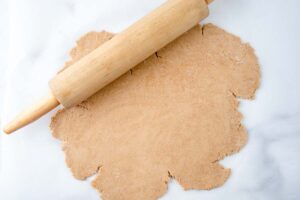 rolling pin and rolled out gingerbread dog treats dough.