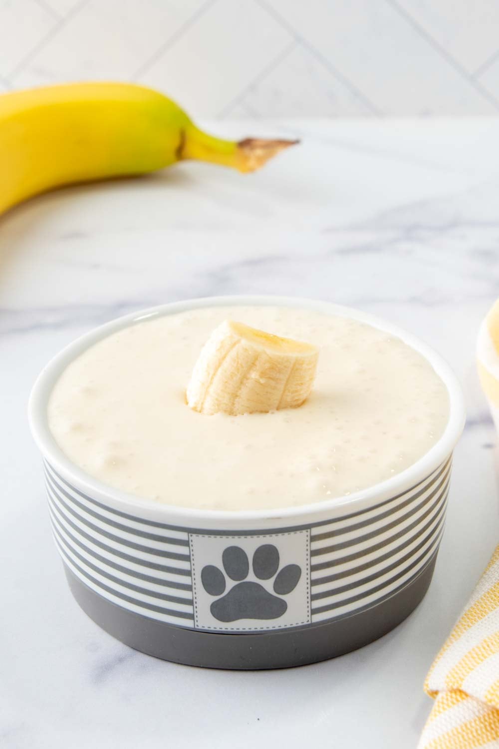 Banana dog smoothie in a small dog bowl and a banana.