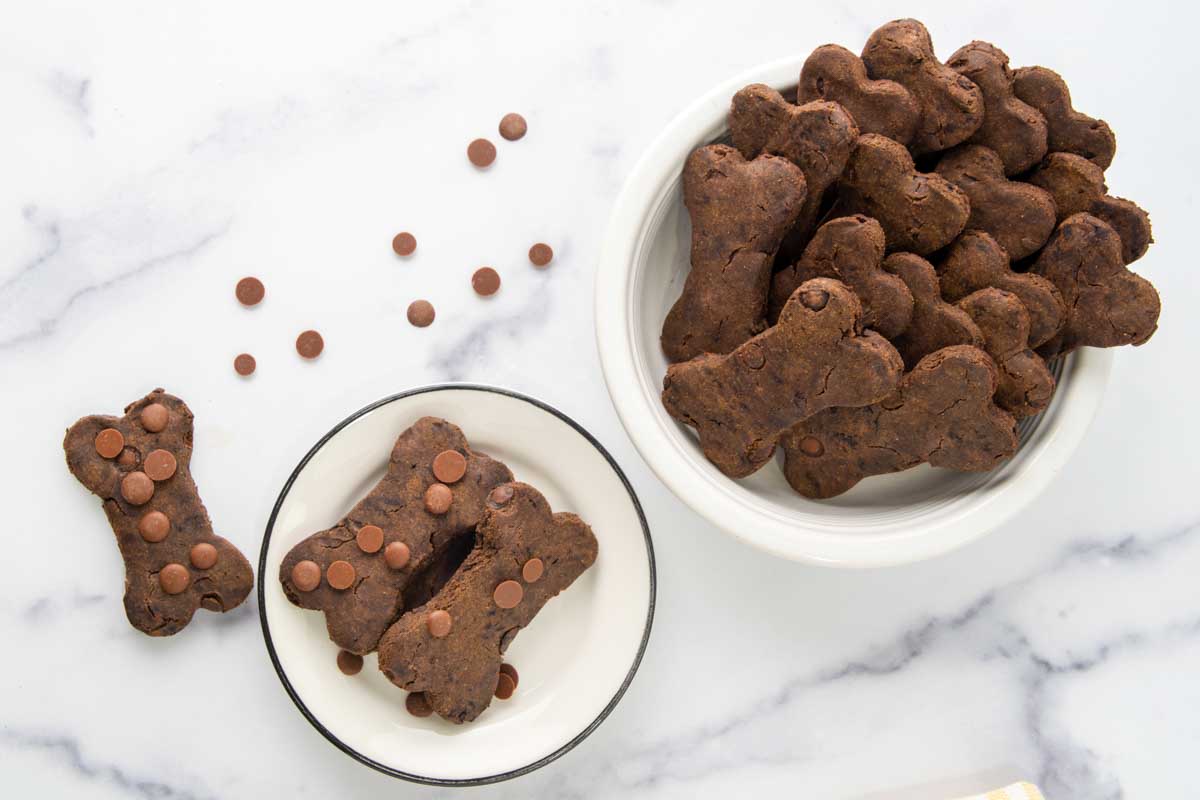 Homemade carob dog treats on a plate and in a bowl.