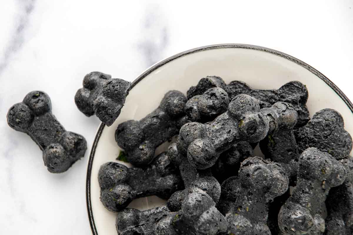 Closeup of a bowl of homemade charcoal dog treats.