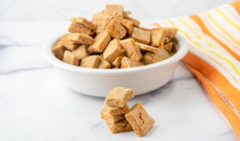 Homemade low calorie dog treats in a stack and in a small bowl.