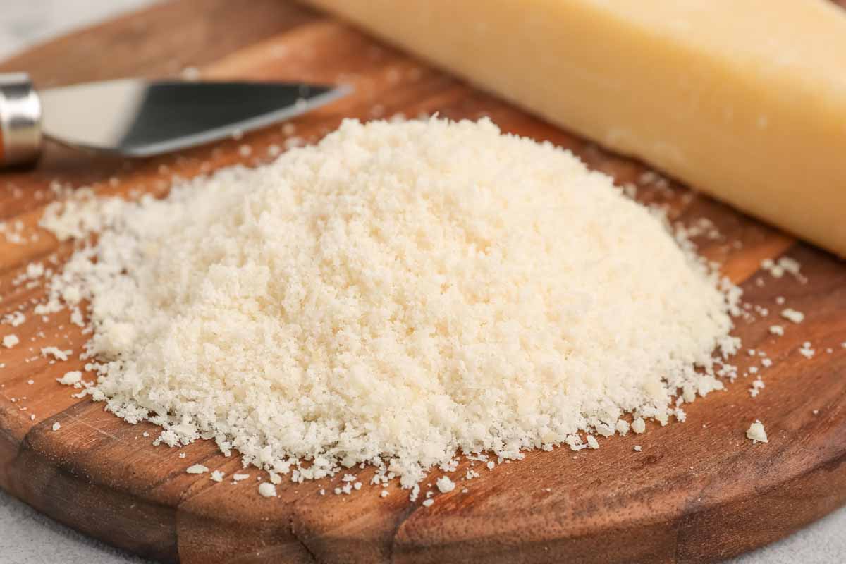 Grated parmesan cheese on a wood board.