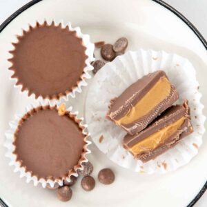 Homemade peanut butter cups for dogs and carob chips on a plate.