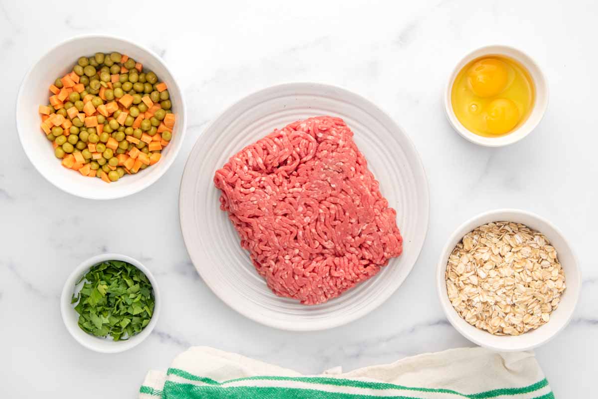 Meatloaf for dogs ingredients on a marble surface.