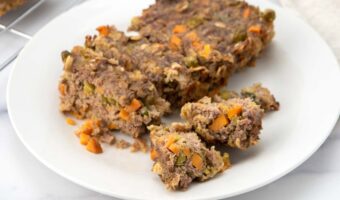 Homemade meatloaf with vegetables for dogs on a plate.