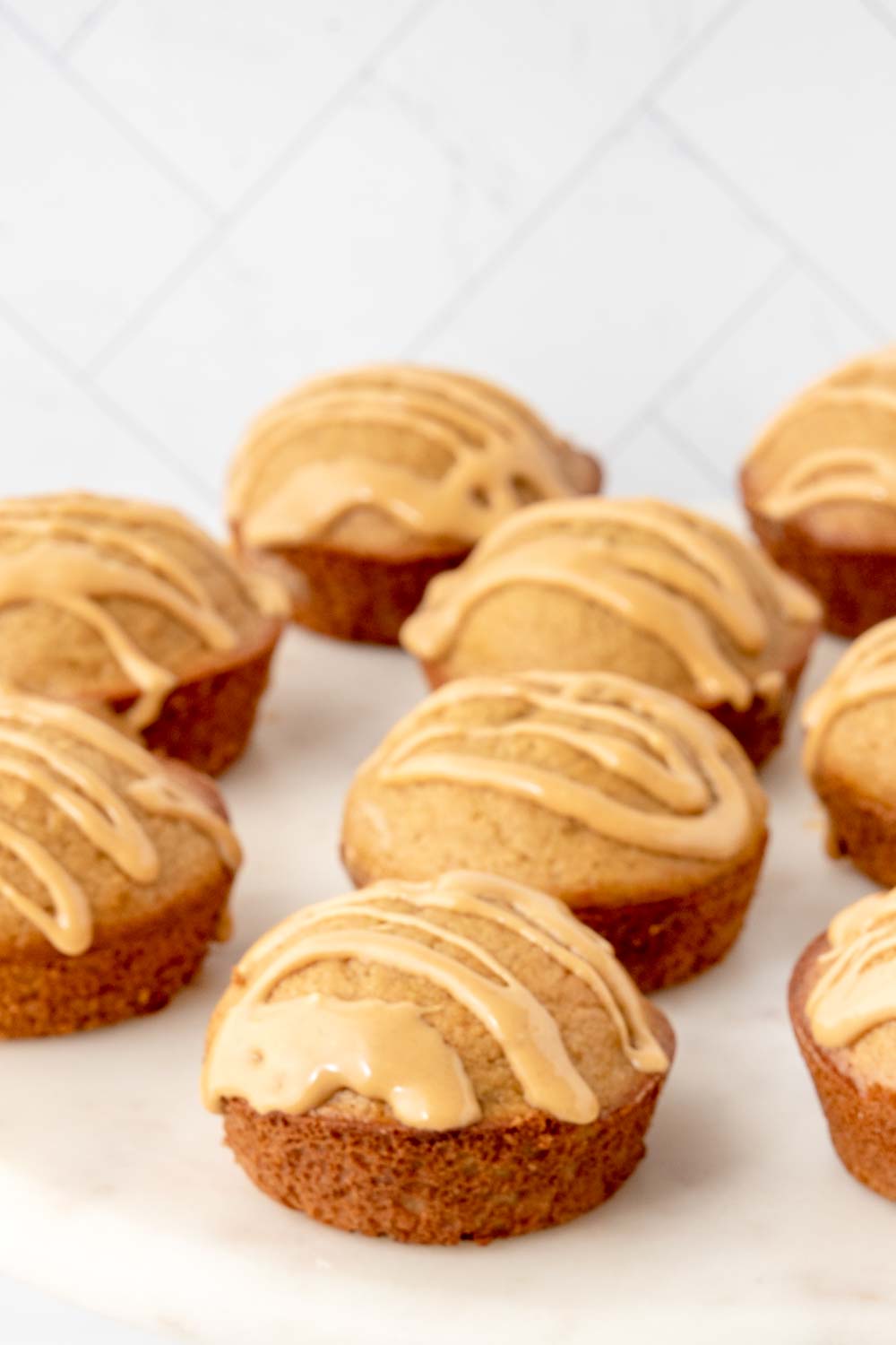 Homemade peanut butter cupcakes for dogs on a marble surface.
