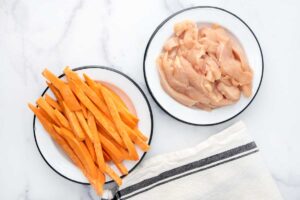 Sliced chicken breast and sweet potato on plates.