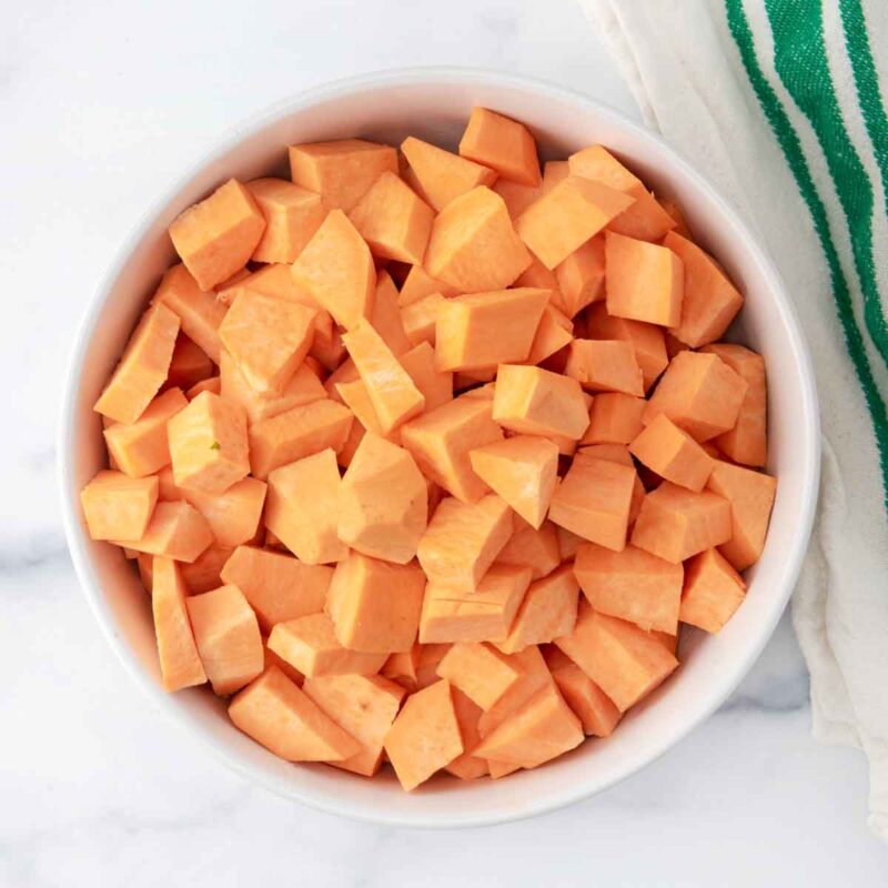 Peeled and chopped sweet potatoes in a bowl.
