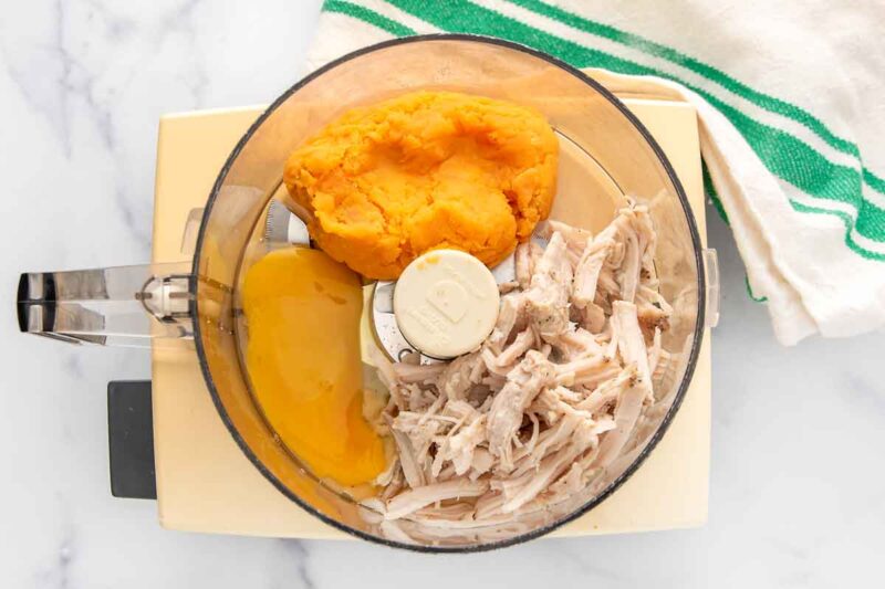 Shredded turkey, cooked sweet potato, and egg in a food processor.
