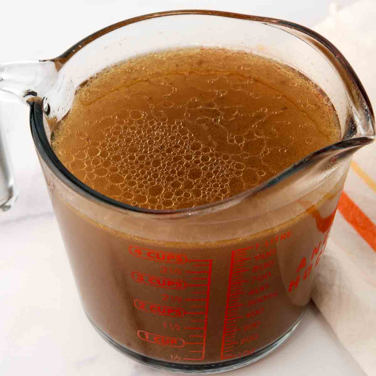 Chicken hearts broth in a measuring cup.