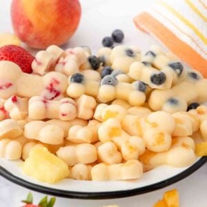 Homemade frozen peach dog treats on a plate.