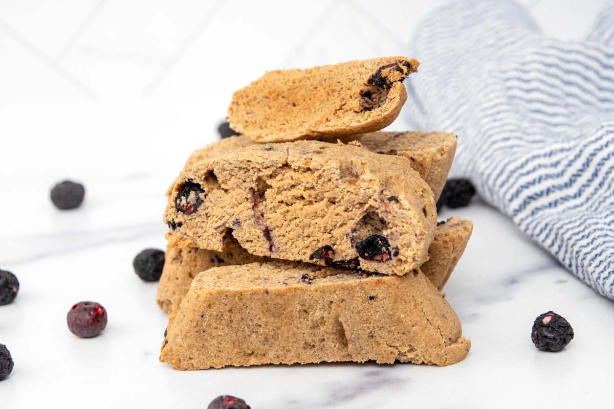 Homemade dog biscotti stacked on a marble surface.