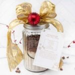 Dog treat mix in a jar decorated with ribbon and recipe card.