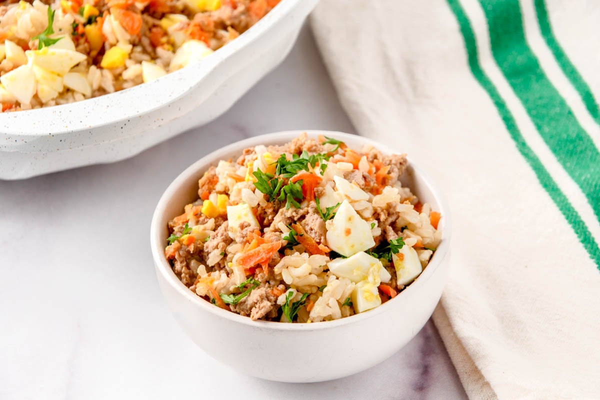 Homemade dog food with eggs in a bowl and a skillet.
