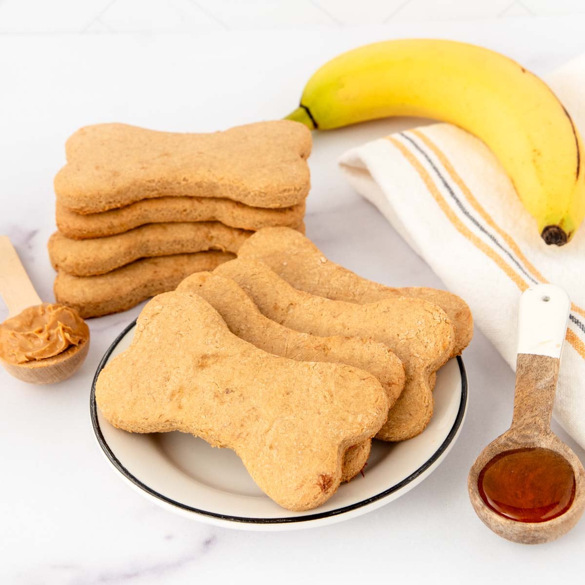 Homemade honey dog treats on a plate and in a stack.