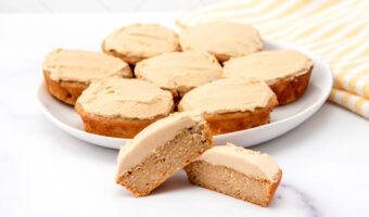 Homemade peanut butter banana pupcakes on a plate and one cut in half in front.