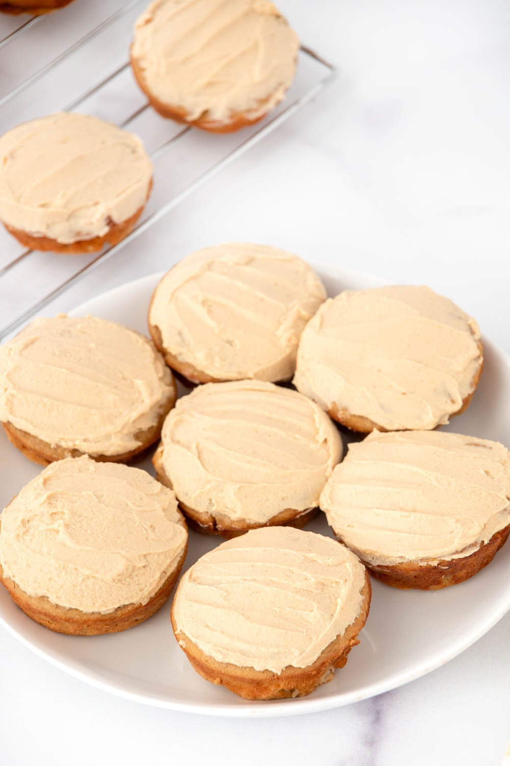 Homemade peanut butter banana pupcakes on a plate and a wire rack.
