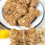Homemade banana oatmeal dog treats in a bowl and tied in a stack.