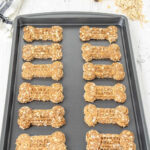 Homemade banana oatmeal dog treats on a baking sheet.