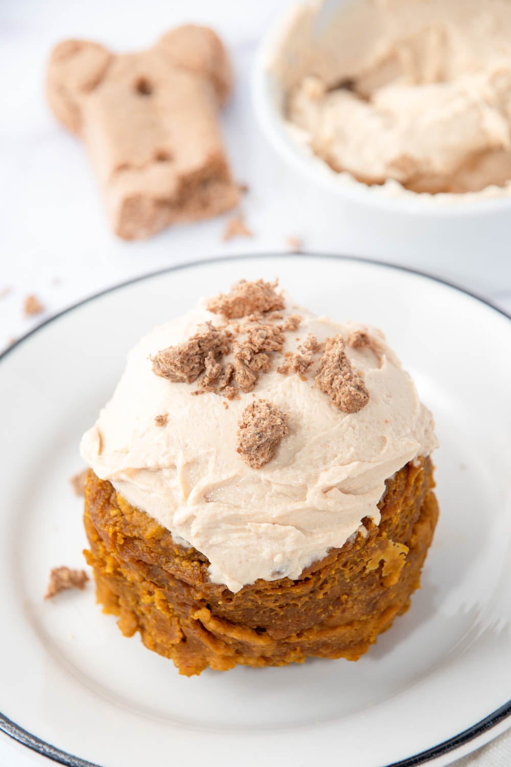 Microwave mug cake for dogs with frosting decorated with crumbled dog treat.