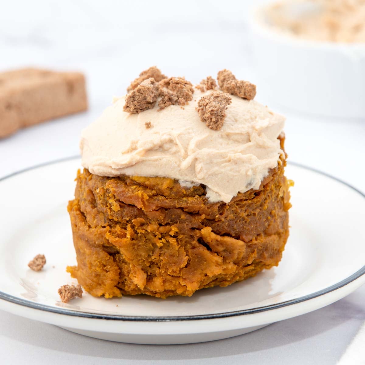 Microwave mug cake for dogs with frosting on a plate.