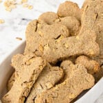 A bowl of homemade bone shaped apple dog treats.