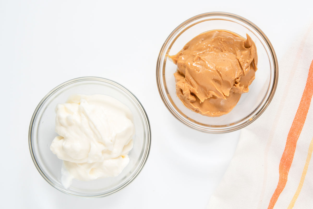 Peanut butter yogurt frosting ingredients in bowls.