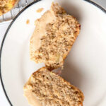 Homemade apple pupcake cut in half on a plate.