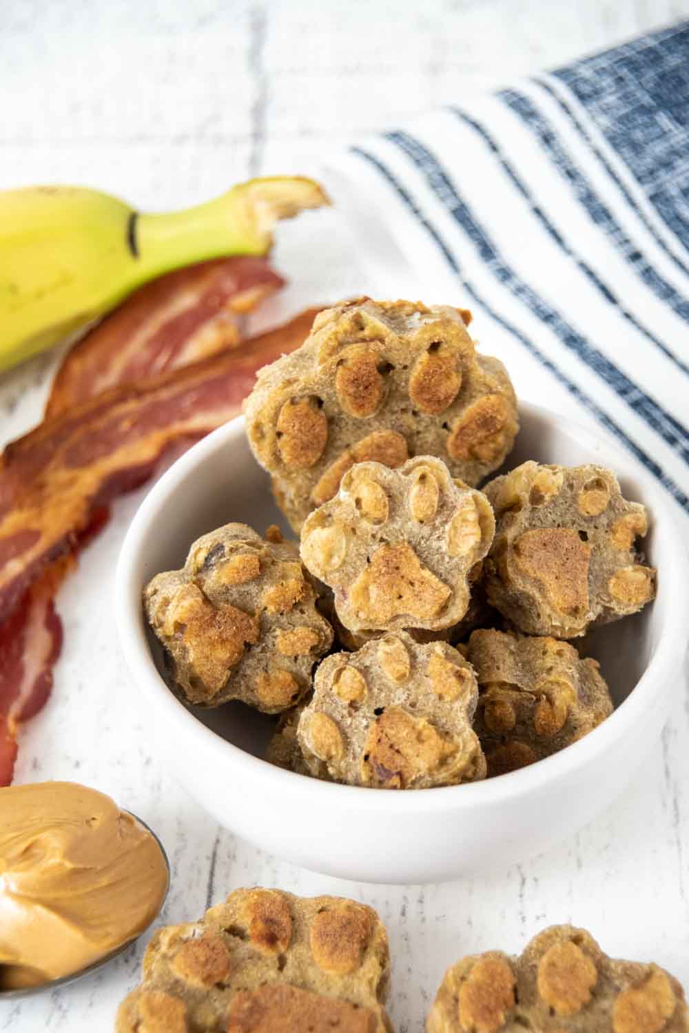 Homemade bacon dog treats, peanut butter, banana, and cooked bacon.