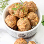 Homemade chicken meatballs for dogs in a dog bowl.