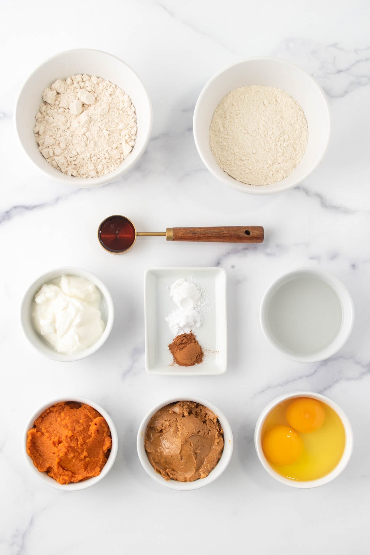 Homemade pumpkin dog cake ingredients in bowls.