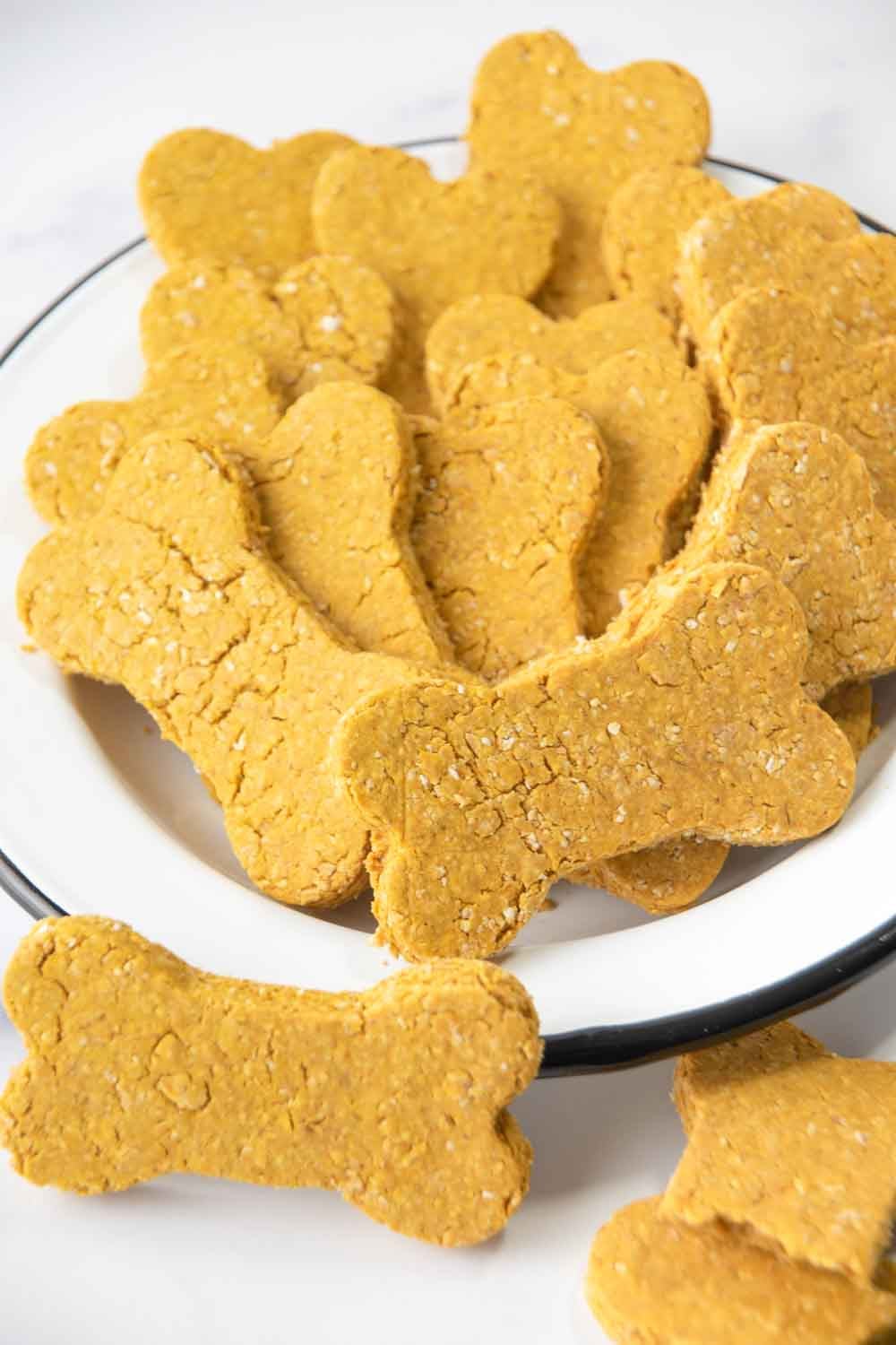 Homemade pumpkin dog cookies in a bowl.
