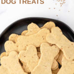Homemade bone-shaped anise dog treats piled on a plate.
